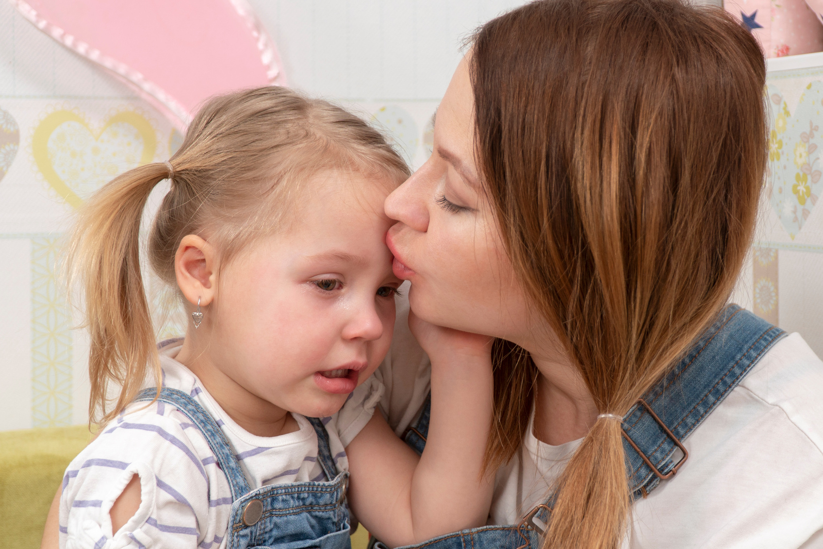 mother kisses a crying child